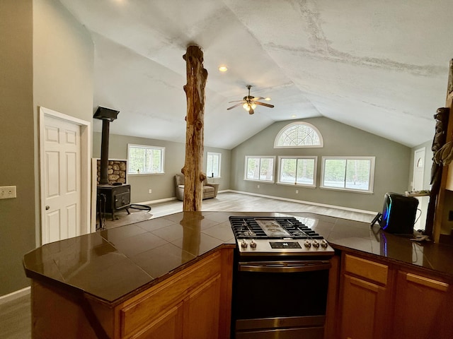 4247 Racoon Trl, Lincoln, MI 48742 - kitchen featuring stainless steel gas range, vaulted ceiling, a ceiling fan, open floor plan, and brown cabinets