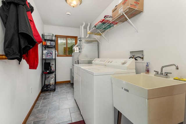 215 Garfield Blvd, Roscommon, MI 48653 - laundry room featuring washer and clothes dryer, baseboards, and light stone finish floors