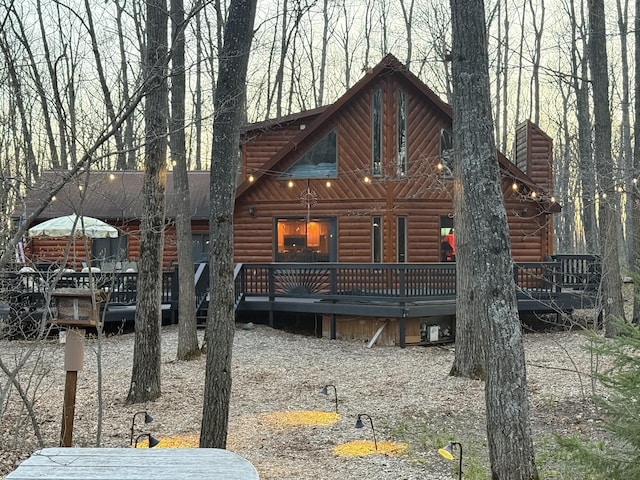 215 Garfield Blvd, Roscommon, MI 48653 - view of front of house featuring log veneer siding and a wooden deck