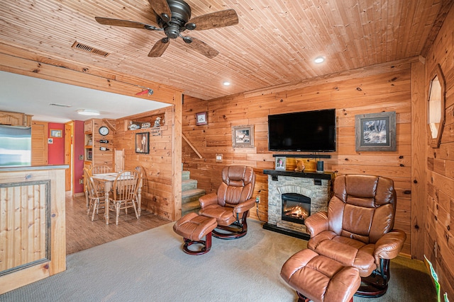 13042 Silver Lake Resort Rd, Wolverine, MI 49799 - living area featuring wooden walls, ceiling fan, wood ceiling, a fireplace, and carpet flooring