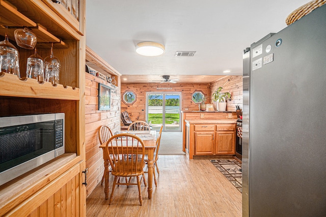 13042 Silver Lake Resort Rd, Wolverine, MI 49799 - dining room with light wood-type flooring, ceiling fan, and wood walls