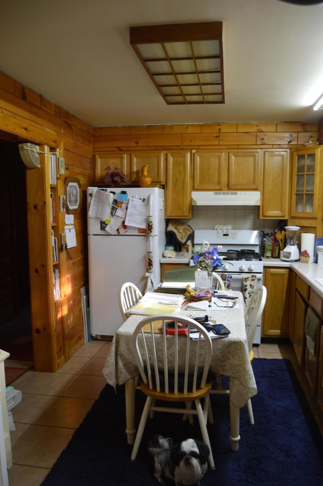 4163 Hanson Rd, Lewiston, MI 49756 - kitchen with white appliances, under cabinet range hood, light countertops, light tile patterned floors, and glass insert cabinets