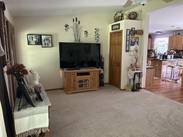676 N Poor Farm Rd, Harrisville, MI 48740 - living area with a ceiling fan, light colored carpet, and baseboards