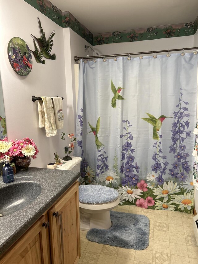 676 N Poor Farm Rd, Harrisville, MI 48740 - full bath featuring vanity, toilet, tile patterned floors, and a shower with shower curtain