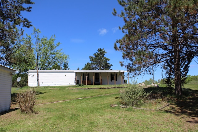 3071 Garling Rd, Fairview, MI 48621 - back of house featuring a lawn and covered porch