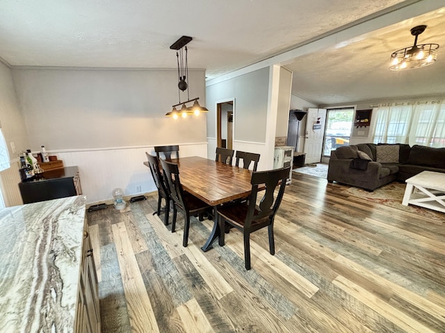 2872 Granger Rd, Lewiston, MI 49756 - dining area featuring wood finished floors, ornamental molding, a wainscoted wall, and a textured ceiling