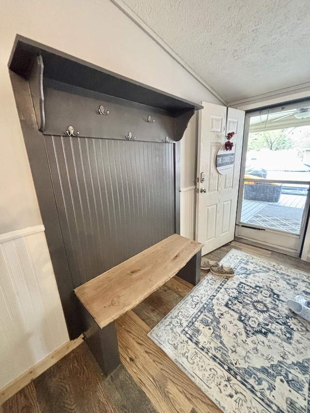 2872 Granger Rd, Lewiston, MI 49756 - mudroom featuring lofted ceiling, wood finished floors, a textured ceiling, and a wainscoted wall