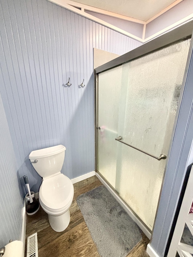 2872 Granger Rd, Lewiston, MI 49756 - bathroom with wood finished floors, toilet, a shower with shower door, and baseboards