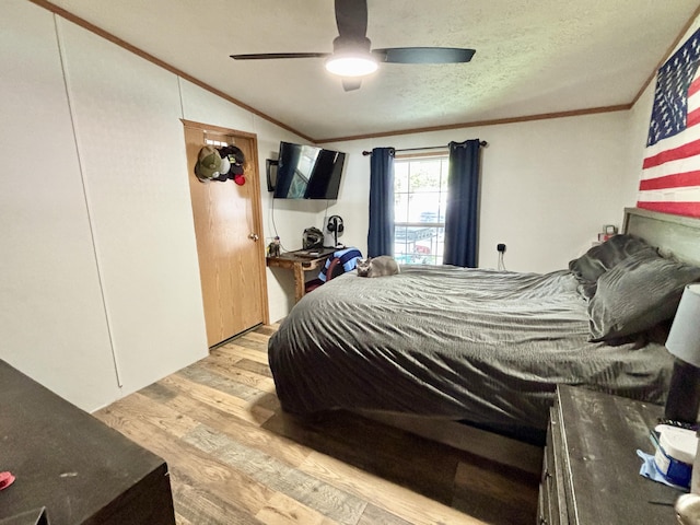 2872 Granger Rd, Lewiston, MI 49756 - bedroom featuring crown molding, light wood finished floors, a ceiling fan, lofted ceiling, and a textured ceiling