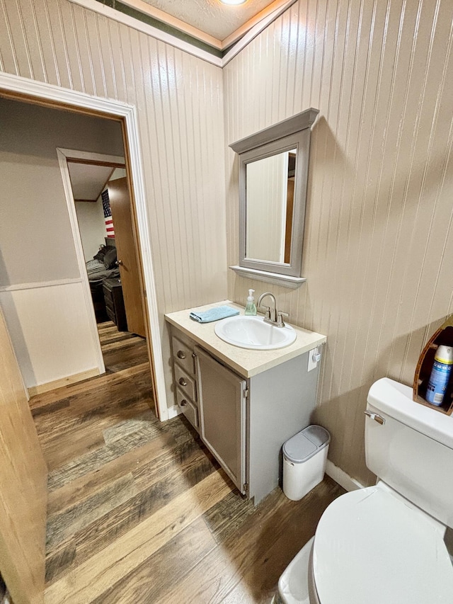 2872 Granger Rd, Lewiston, MI 49756 - bathroom featuring wood finished floors, toilet, vanity, and wood walls
