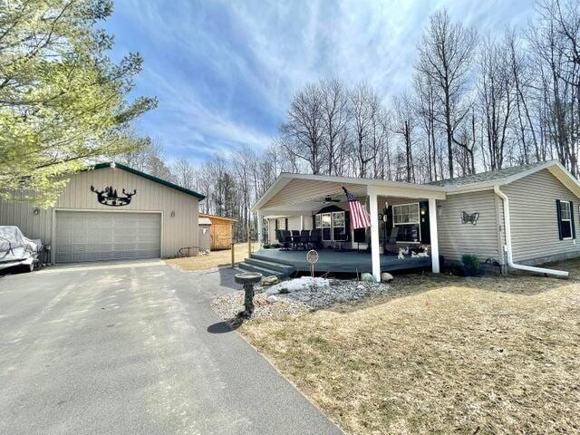 2872 Granger Rd, Lewiston, MI 49756 - view of front of house with covered porch, an outdoor structure, a garage, and driveway