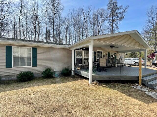 2872 Granger Rd, Lewiston, MI 49756 - view of property exterior featuring ceiling fan, an attached carport, a wooden deck, crawl space, and a lawn