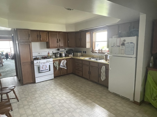 120 S Indiana Ave, Gaylord, MI 49735 - kitchen featuring white appliances, a sink, and light countertops