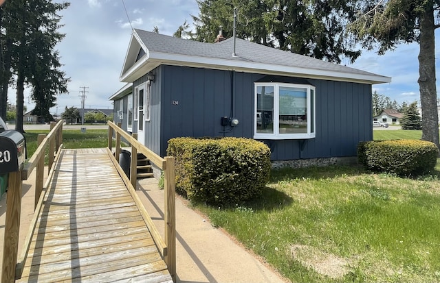 120 S Indiana Ave, Gaylord, MI 49735 - view of property exterior with board and batten siding, roof with shingles, and a yard