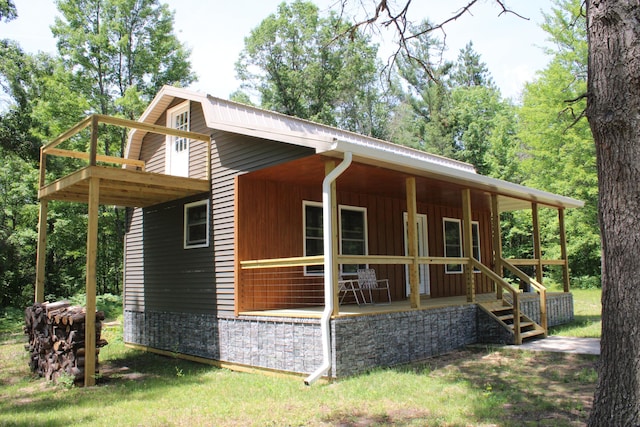 186 S Gerber Rd, Mio, MI 48647 - view of front of property with covered porch, stone siding, and board and batten siding