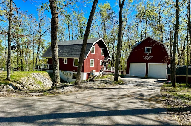 19110 Red Pine Dr, Hillman, MI 49746 - view of property exterior featuring a detached garage, a gambrel roof, an outbuilding, and a barn