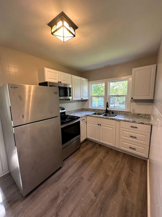 310 W Campbell St, Alpena, MI 49707 - kitchen featuring appliances with stainless steel finishes, a sink, dark wood-type flooring, and white cabinets