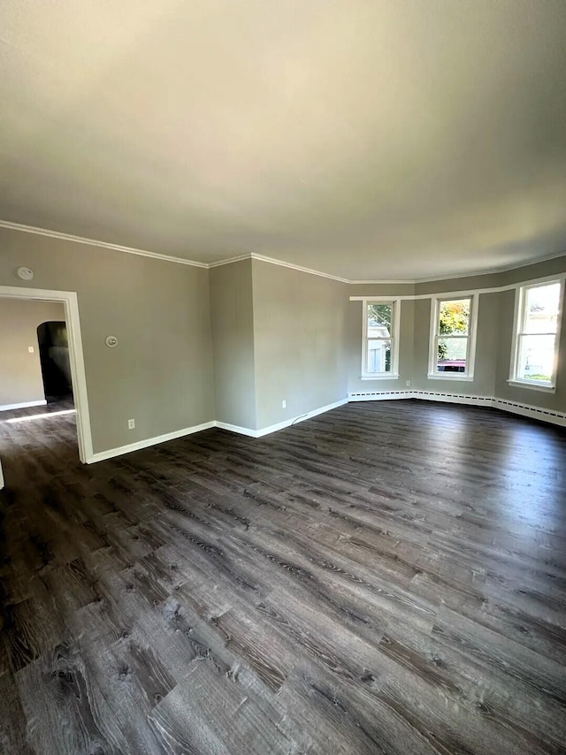 310 W Campbell St, Alpena, MI 49707 - unfurnished living room with baseboards, ornamental molding, dark wood finished floors, and arched walkways