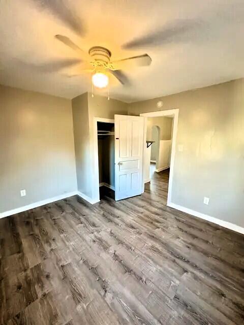 310 W Campbell St, Alpena, MI 49707 - unfurnished bedroom featuring baseboards, dark wood finished floors, a closet, and ceiling fan
