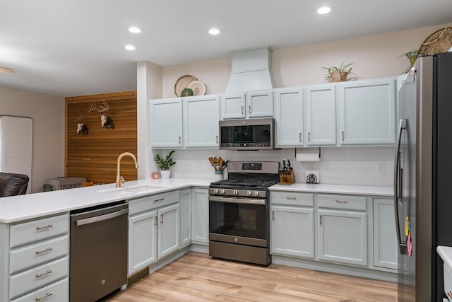 11882 Davis Creek Dr, Wolverine, MI 49799 - kitchen featuring appliances with stainless steel finishes, a sink, a peninsula, tasteful backsplash, and light countertops