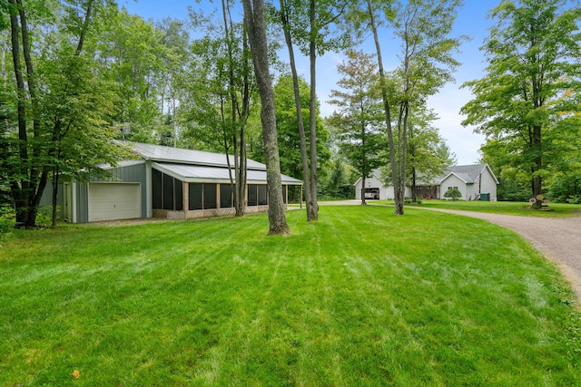 11882 Davis Creek Dr, Wolverine, MI 49799 - view of green lawn with driveway, a detached garage, and an outdoor structure