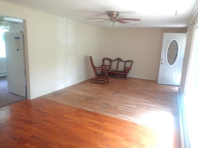 410 Terrace Dr, Houghton Lake, MI 48629 - unfurnished room with a ceiling fan, wood finished floors, and a baseboard radiator