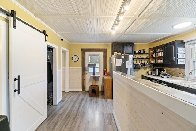 202 E 3rd St, Gaylord, MI 49735 - kitchen featuring a barn door, a sink, light wood finished floors, freestanding refrigerator, and open shelves