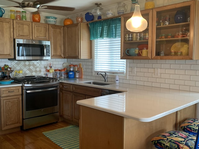 1253 N Partridge Point Rd, Alpena, MI 49707 - kitchen with appliances with stainless steel finishes, light countertops, wood finished floors, a peninsula, and a sink