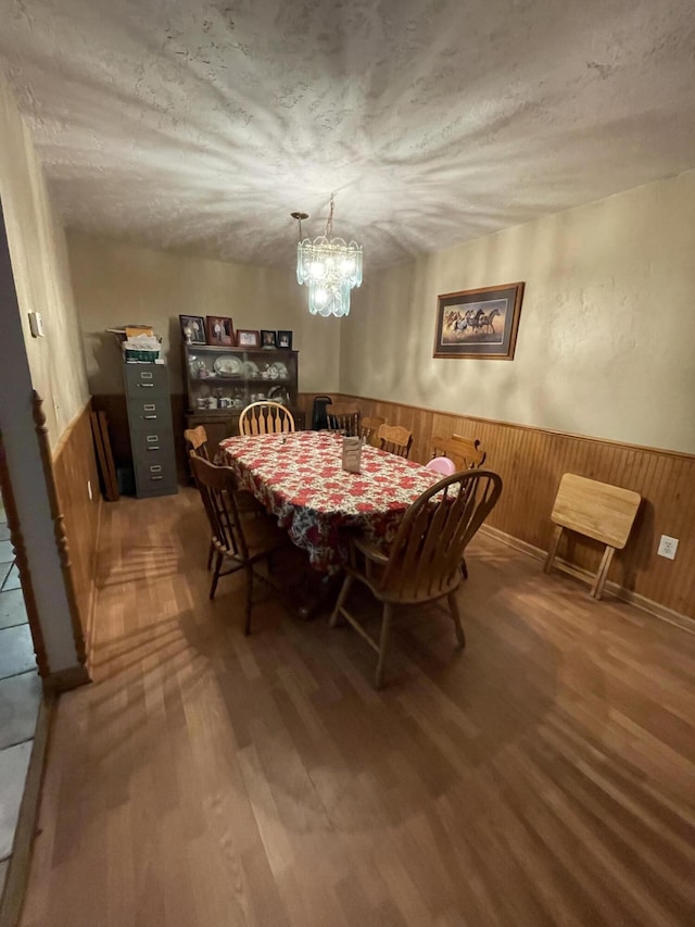 445 Noric Dr, Roscommon, MI 48653 - dining space featuring wood finished floors, a chandelier, wainscoting, and wooden walls