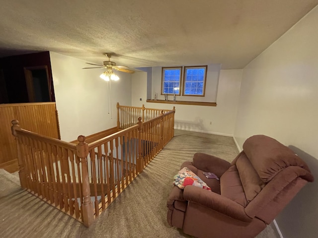 445 Noric Dr, Roscommon, MI 48653 - living area featuring an upstairs landing, carpet flooring, baseboards, a textured ceiling, and a ceiling fan