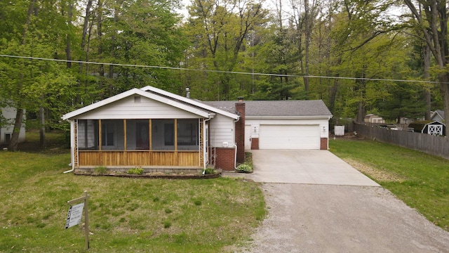 206 Harvey Ave, Houghton Lake, MI 48629 - view of front of house featuring brick siding, a garage, a sunroom, driveway, and a chimney