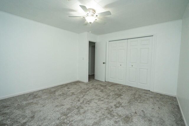 206 Harvey Ave, Houghton Lake, MI 48629 - unfurnished bedroom featuring carpet floors, a closet, baseboards, and a ceiling fan