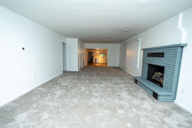 206 Harvey Ave, Houghton Lake, MI 48629 - unfurnished living room featuring carpet floors, a fireplace, and baseboards