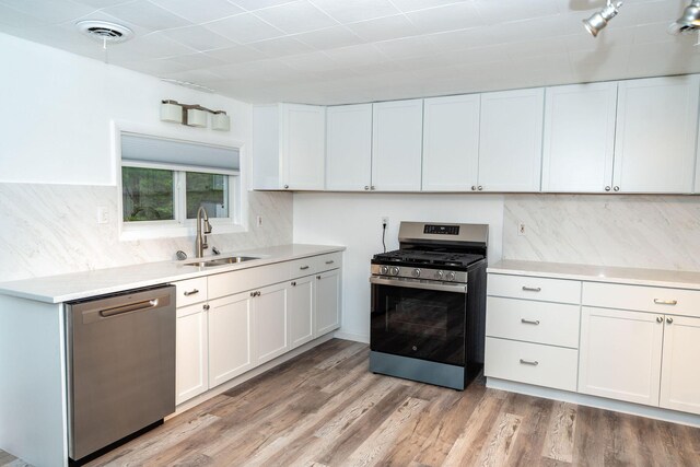 206 Harvey Ave, Houghton Lake, MI 48629 - kitchen featuring stainless steel appliances, a sink, light countertops, and decorative backsplash
