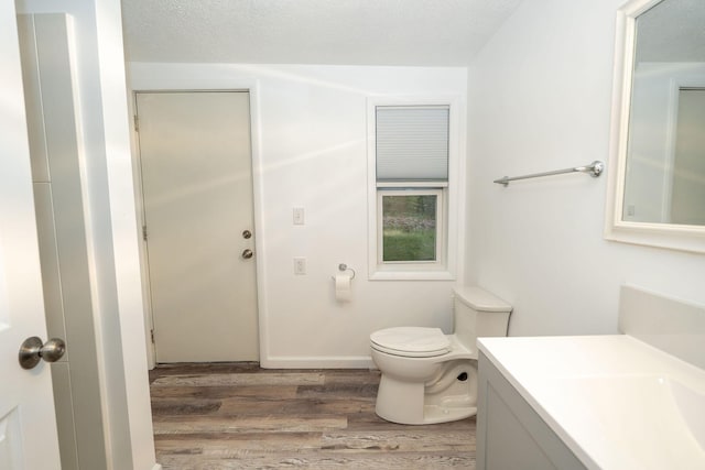 206 Harvey Ave, Houghton Lake, MI 48629 - bathroom featuring wood finished floors, vanity, and toilet
