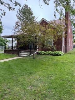 18598 Henry St, Melvindale, MI 48122 - view of property hidden behind natural elements with a front lawn and a chimney