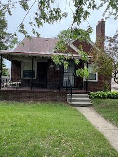 18598 Henry St, Melvindale, MI 48122 - view of front of home with brick siding, a front yard, a porch, and a chimney