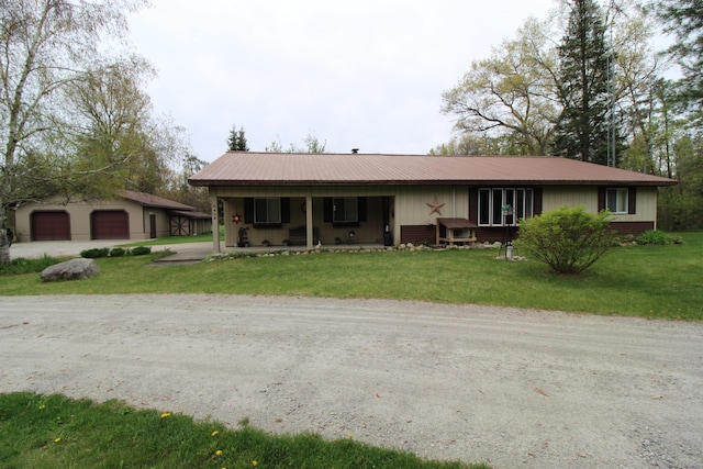 5432 E Michigan Hwy, Roscommon, MI 48653 - single story home with a detached garage, a front yard, metal roof, and a porch