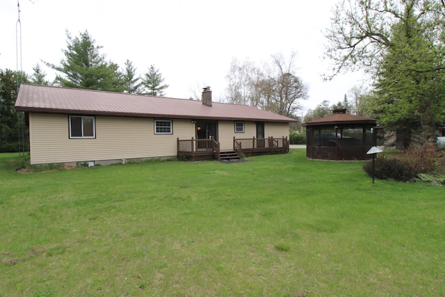 5432 E Michigan Hwy, Roscommon, MI 48653 - rear view of house with a gazebo, a wooden deck, a lawn, metal roof, and a chimney