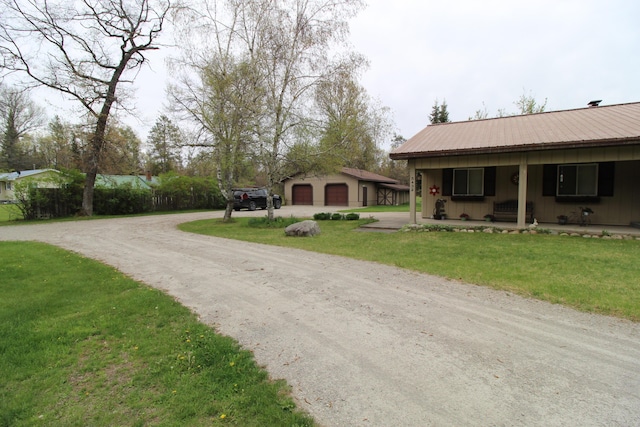 5432 E Michigan Hwy, Roscommon, MI 48653 - view of front of property with a detached garage, covered porch, a front yard, an outdoor structure, and metal roof