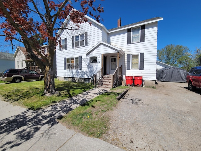 615 W Lake St, Alpena, MI 49707 - traditional home with a chimney and a front yard
