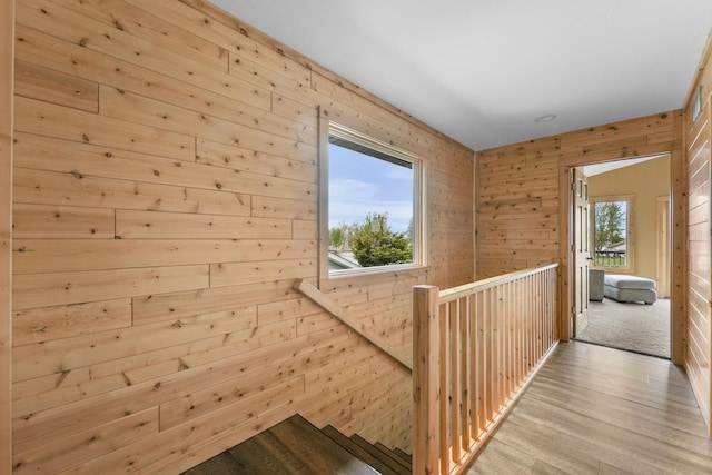 6801 Driftwood Cv, Saint Helen, MI 48656 - hallway featuring an upstairs landing, wood finished floors, and wood walls