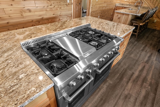 6801 Driftwood Cv, Saint Helen, MI 48656 - kitchen view of range with gas cooktop, wooden walls, light stone countertops, dark wood-style flooring, and a sink