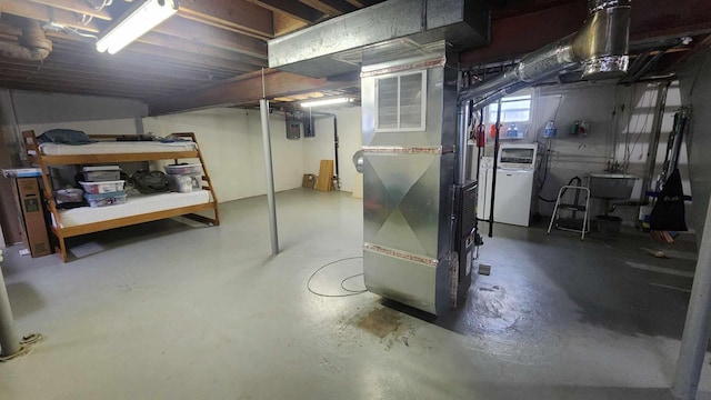 8619A Iowa St, Oscoda, MI 48750 - basement with washer / clothes dryer, heating unit, and a sink