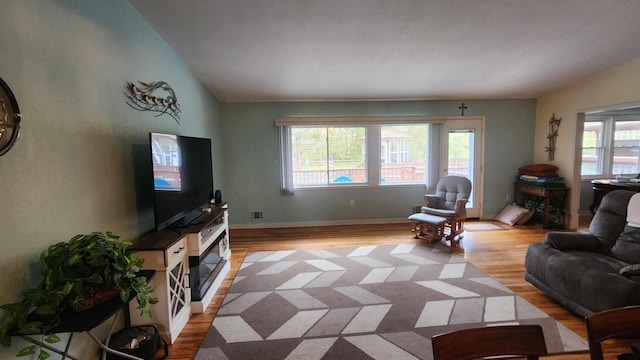8619A Iowa St, Oscoda, MI 48750 - living area with light wood-style floors, a fireplace, lofted ceiling, and baseboards