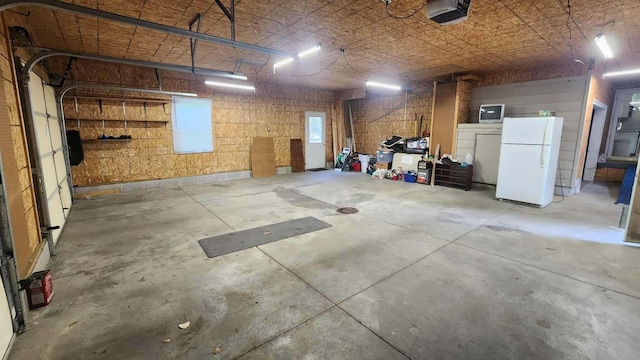 8619A Iowa St, Oscoda, MI 48750 - garage with freestanding refrigerator and a garage door opener
