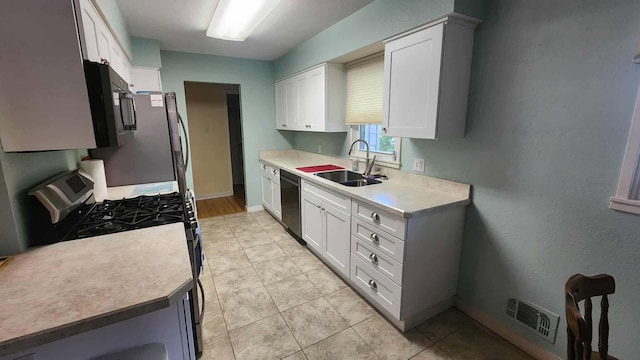 8619A Iowa St, Oscoda, MI 48750 - kitchen with appliances with stainless steel finishes, light countertops, white cabinets, and light tile patterned floors