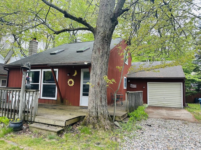 205 Beechwood Ave, Houghton Lake, MI 48629 - view of front of property featuring a chimney, a deck, roof with shingles, and driveway
