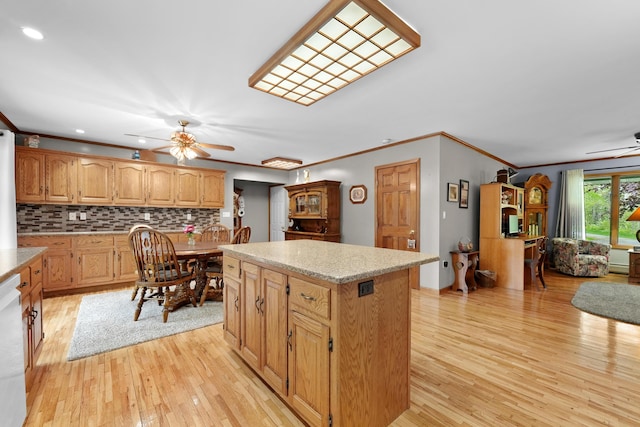 4285 Tower Hill Rd, Houghton Lake, MI 48629 - kitchen featuring a ceiling fan, ornamental molding, a center island, light wood-type flooring, and decorative backsplash