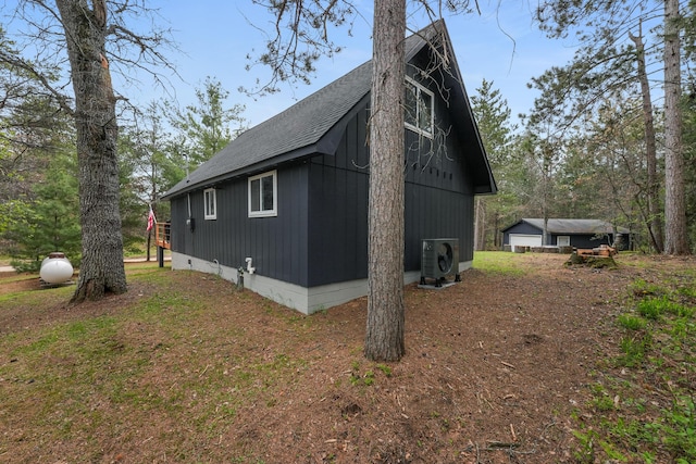 7028 Merrio Rd, Grayling, MI 49738 - view of side of home with a shingled roof, ac unit, and an outdoor structure
